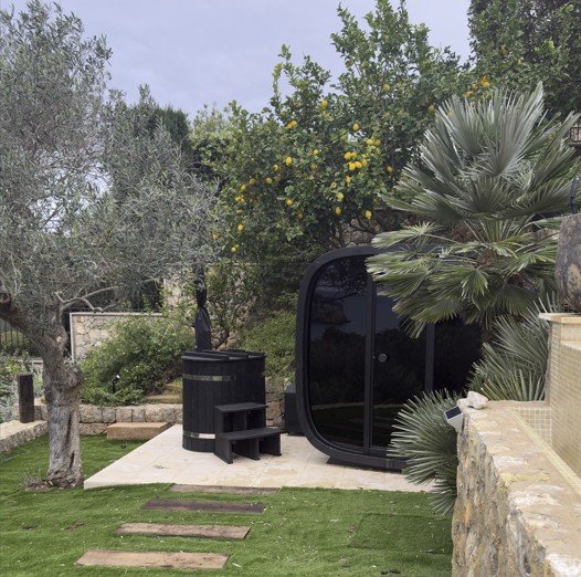 Outdoor sauna pod and cold plunge barrel in a Mallorca garden